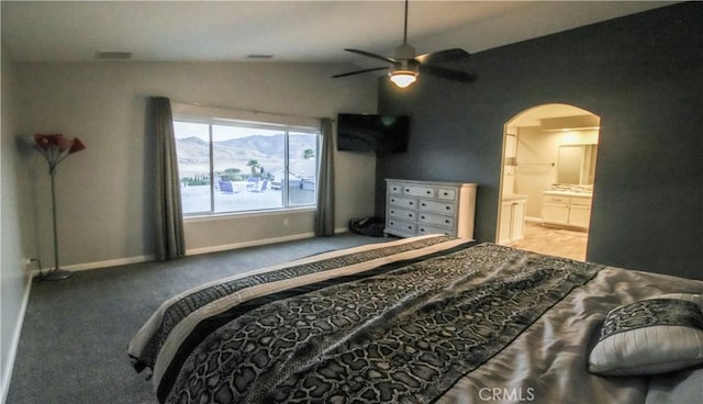 bedroom with a ceiling fan, baseboards, arched walkways, vaulted ceiling, and light carpet