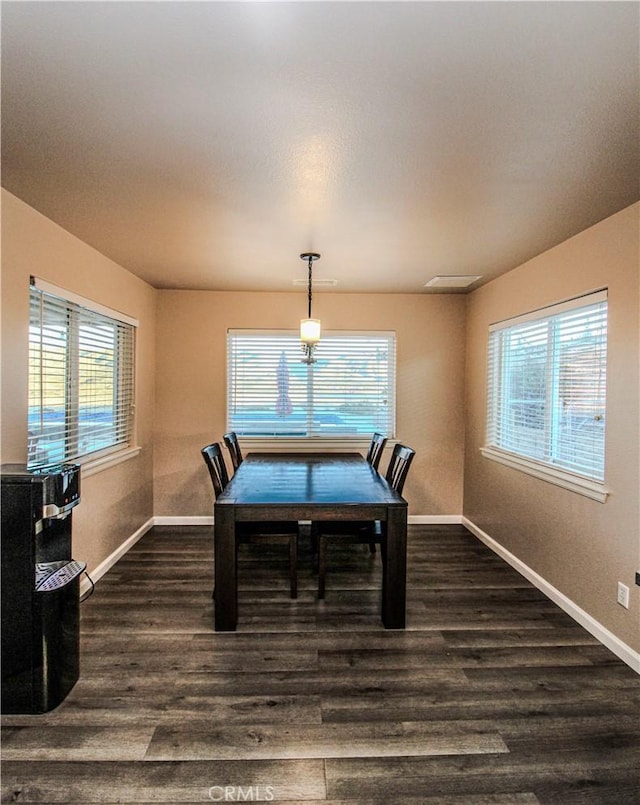 dining space featuring baseboards and dark wood-style flooring