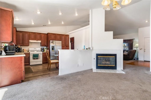 kitchen with light carpet, stainless steel fridge with ice dispenser, white gas range oven, vaulted ceiling, and a tiled fireplace