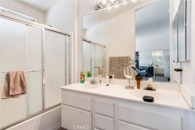 bathroom featuring bath / shower combo with glass door and vanity