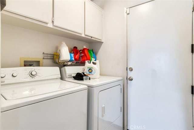 washroom with washer and clothes dryer and cabinets