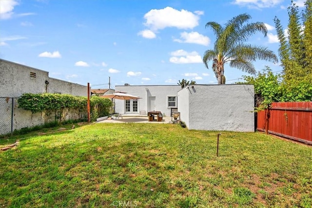 rear view of house featuring a yard and a patio