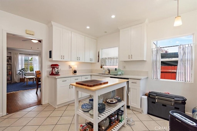 kitchen featuring light tile patterned floors, pendant lighting, and white cabinets