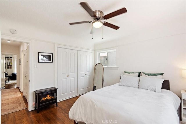 bedroom with ceiling fan, dark hardwood / wood-style floors, and a closet