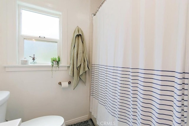 bathroom featuring toilet and walk in shower