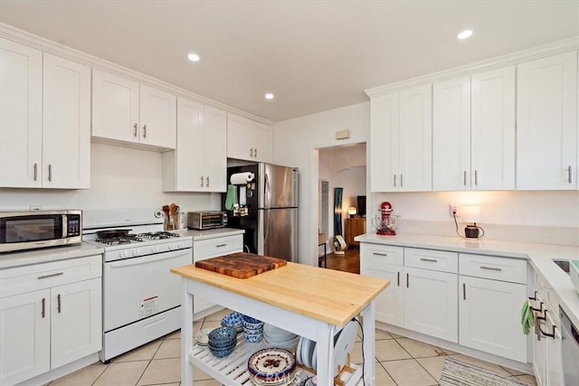 kitchen featuring white cabinets, light tile patterned floors, and stainless steel appliances