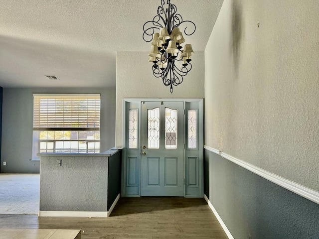 entrance foyer with wood-type flooring and a chandelier