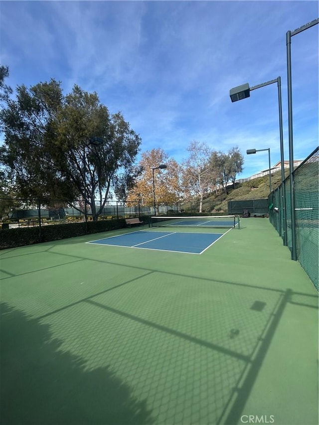 view of tennis court with basketball hoop