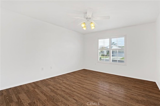 spare room with dark hardwood / wood-style flooring and ceiling fan