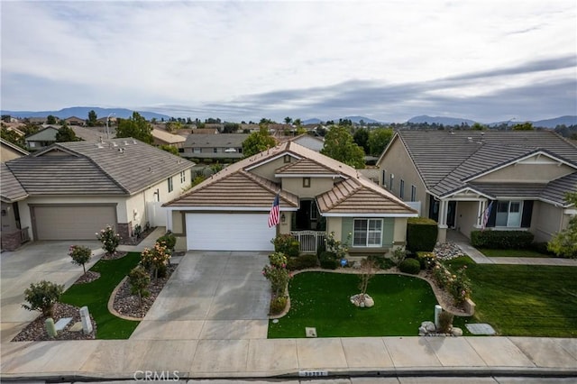 single story home with a mountain view, a garage, and a front yard