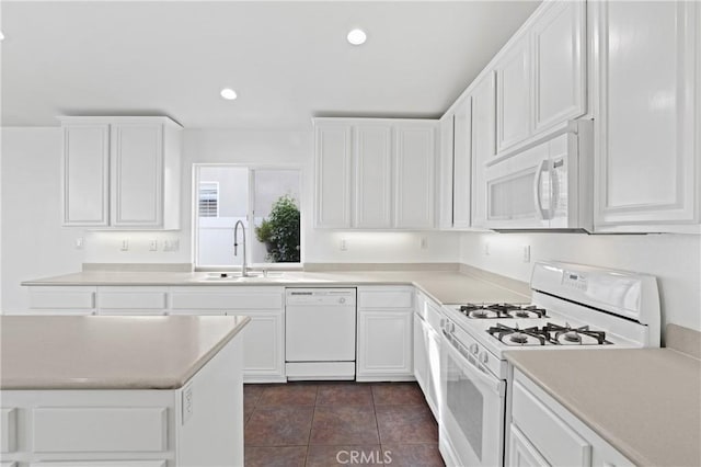 kitchen featuring sink, white appliances, white cabinets, and dark tile patterned flooring