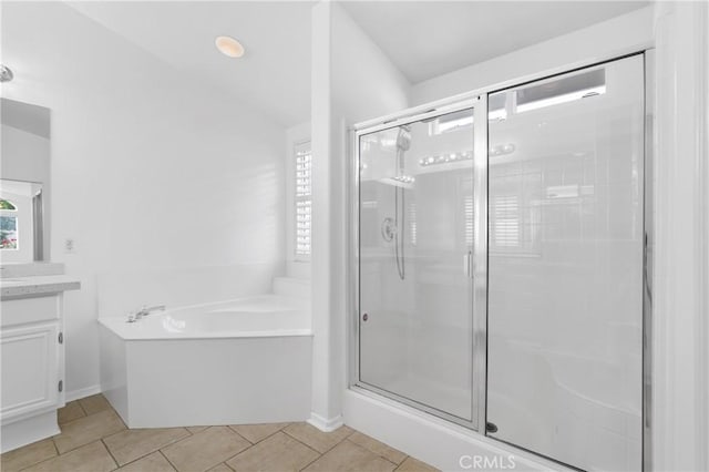 bathroom with tile patterned flooring, vanity, and plus walk in shower