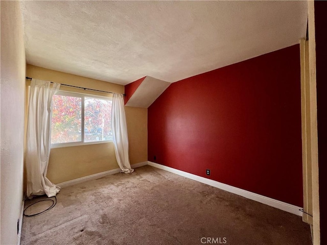 additional living space with vaulted ceiling, a textured ceiling, and carpet flooring