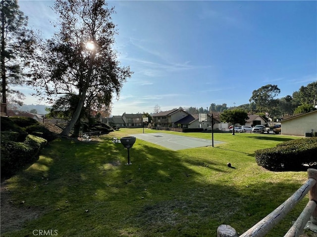 view of home's community with a yard and basketball hoop