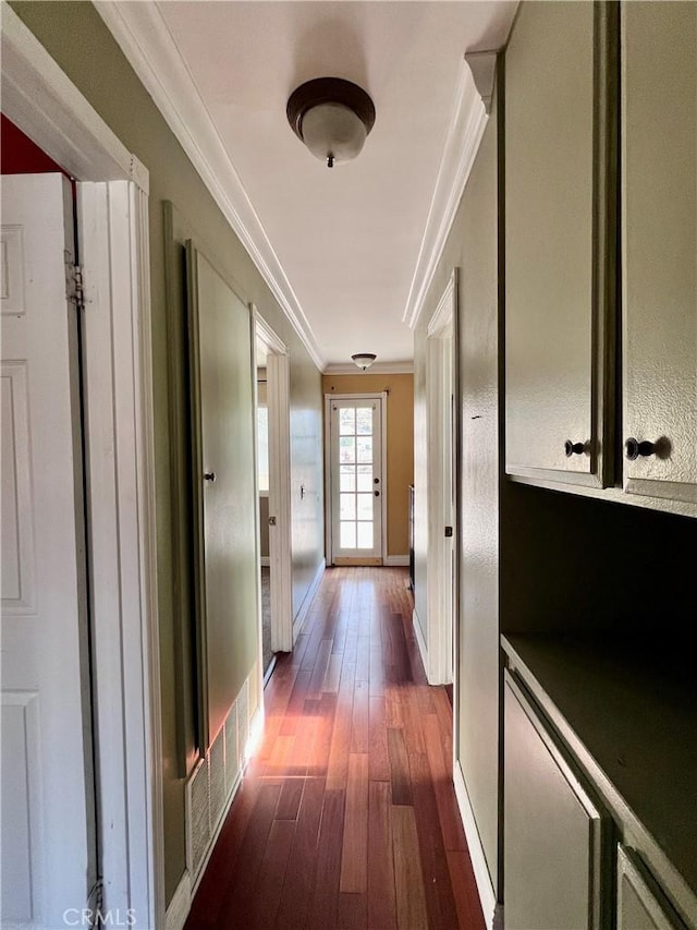 corridor with dark hardwood / wood-style flooring and ornamental molding