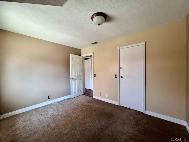 unfurnished bedroom with carpet floors and a textured ceiling