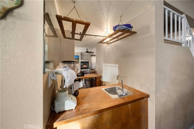 interior space featuring ceiling fan, sink, and a textured ceiling