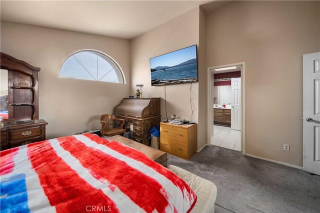 bedroom featuring connected bathroom and light colored carpet