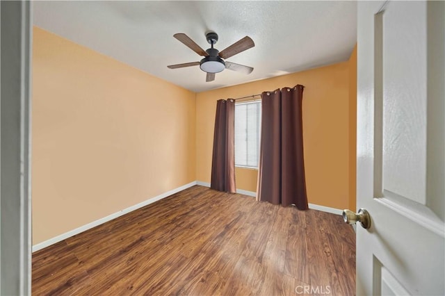 empty room with ceiling fan and hardwood / wood-style flooring