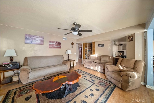 living room with ceiling fan and light hardwood / wood-style flooring