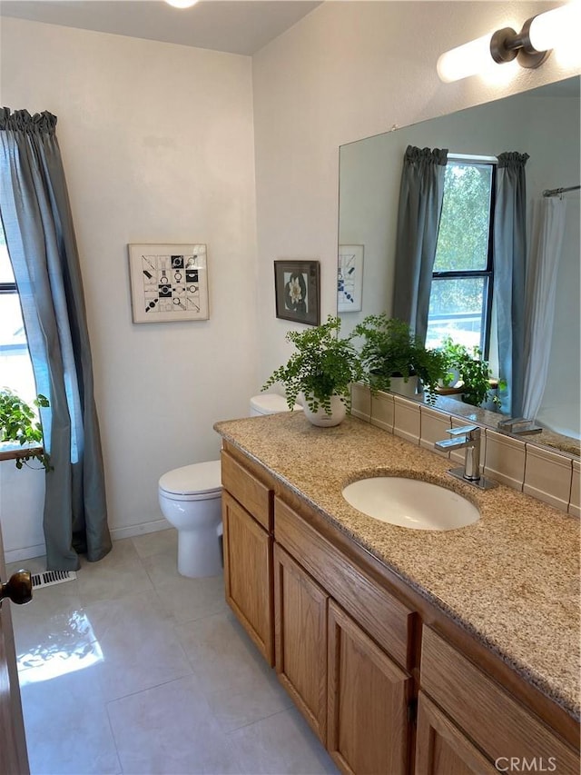 bathroom featuring toilet, tile patterned floors, and vanity