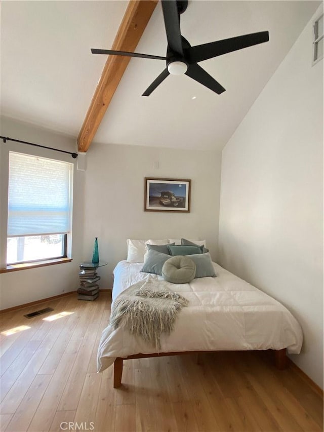 bedroom with ceiling fan, light hardwood / wood-style floors, and vaulted ceiling with beams