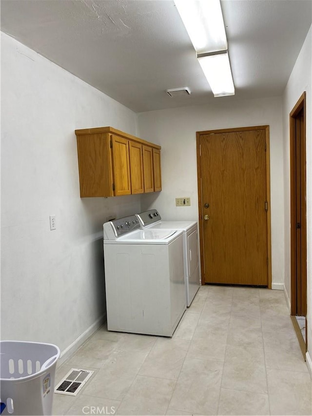 washroom with washer and dryer and cabinets