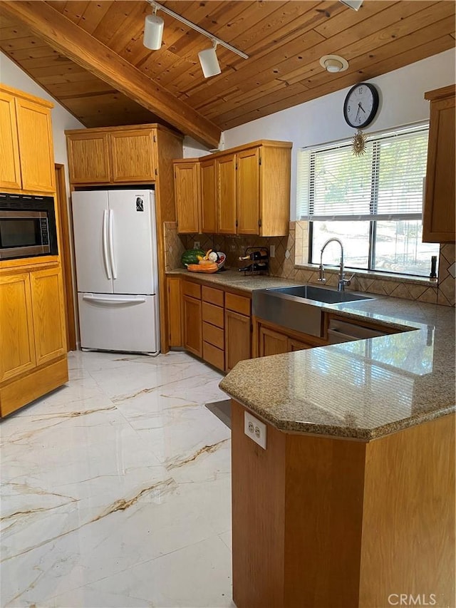 kitchen with wooden ceiling, backsplash, stainless steel microwave, and white refrigerator