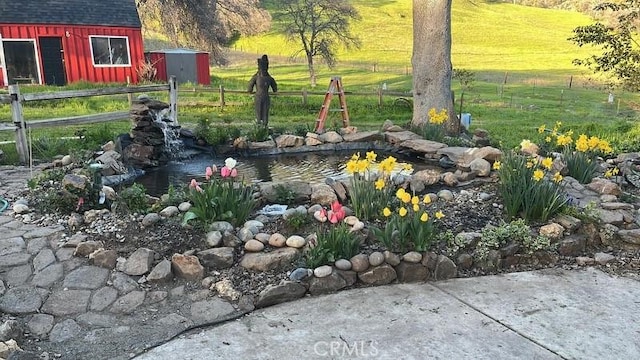 view of yard featuring a storage unit and a small pond