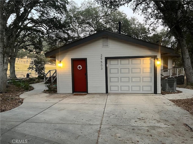 garage at dusk featuring central air condition unit