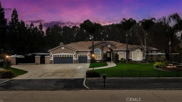 view of front of home with concrete driveway, stone siding, an attached garage, a fenced front yard, and a front yard