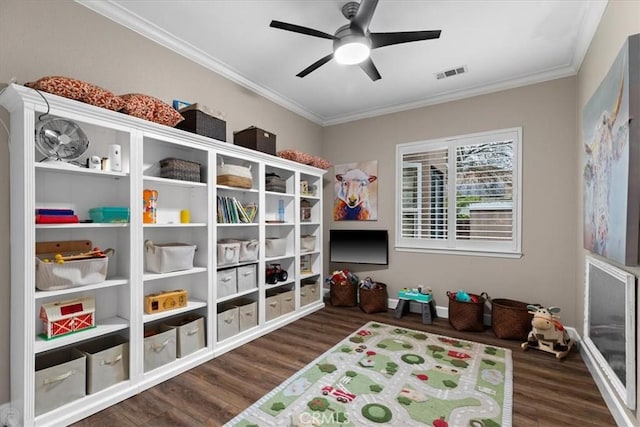 playroom with ceiling fan, dark hardwood / wood-style flooring, and crown molding