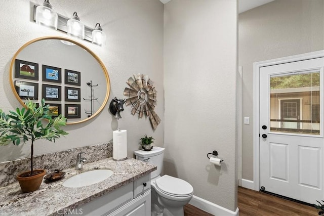 bathroom featuring toilet, hardwood / wood-style floors, and vanity