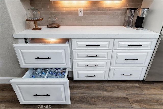 bar featuring dark hardwood / wood-style floors, decorative backsplash, and white cabinets