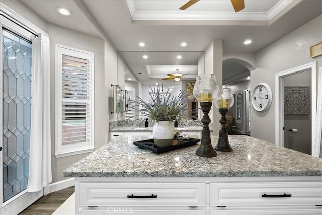 interior space featuring hardwood / wood-style flooring, a tray ceiling, and crown molding