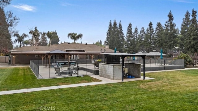 rear view of property featuring a lawn, a gazebo, and exterior bar