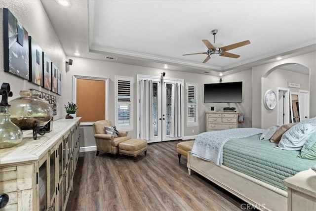 bedroom featuring hardwood / wood-style floors, ceiling fan, a tray ceiling, french doors, and ornamental molding