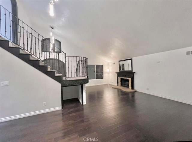 unfurnished living room featuring dark wood-type flooring and lofted ceiling