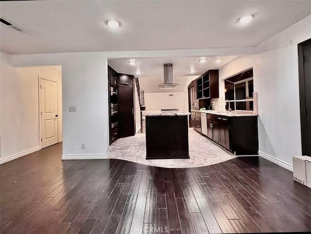 kitchen featuring sink, hardwood / wood-style flooring, a center island, and wall chimney exhaust hood