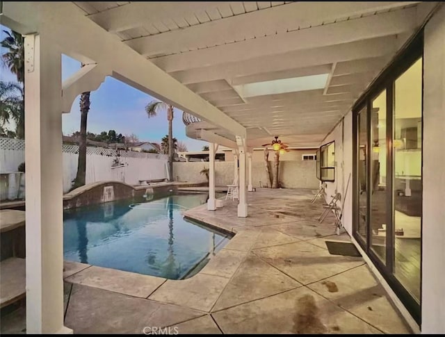 pool at dusk featuring a patio