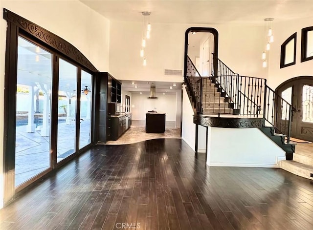 entryway featuring french doors, a towering ceiling, and dark hardwood / wood-style flooring