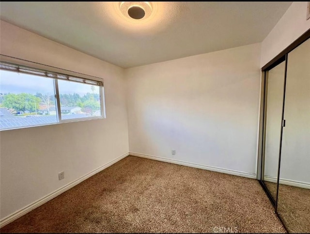 unfurnished bedroom with carpet flooring and a closet