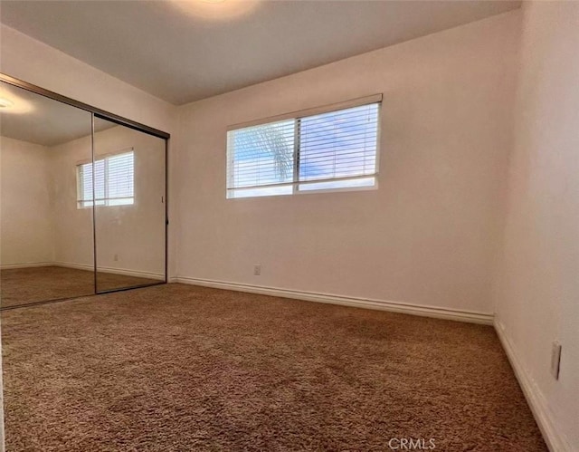 unfurnished bedroom featuring carpet flooring and a closet