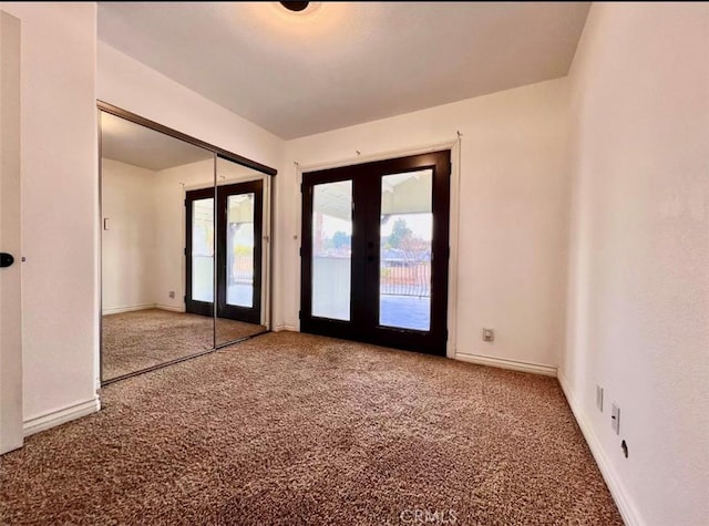 unfurnished room featuring french doors and carpet floors