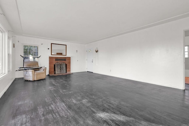 unfurnished living room with a brick fireplace and dark hardwood / wood-style floors