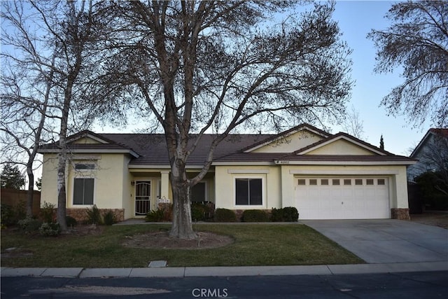 ranch-style house featuring a garage and a front yard