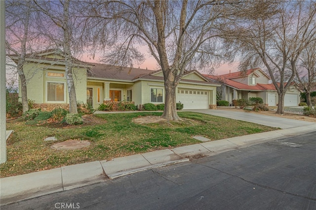 view of front of house featuring a garage and a yard