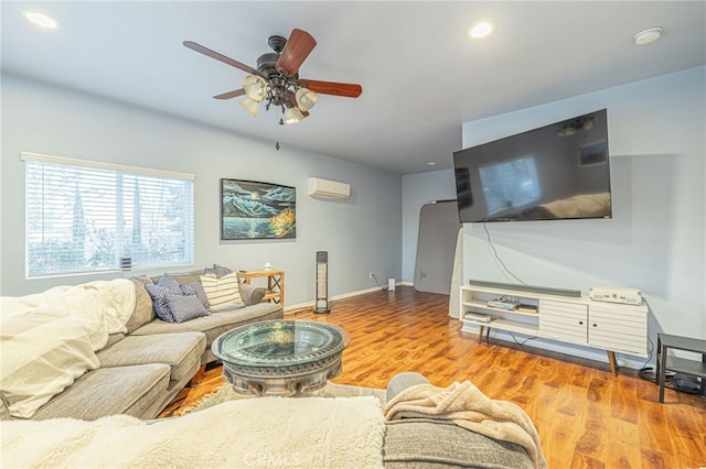 living room with ceiling fan, wood-type flooring, and a wall mounted air conditioner