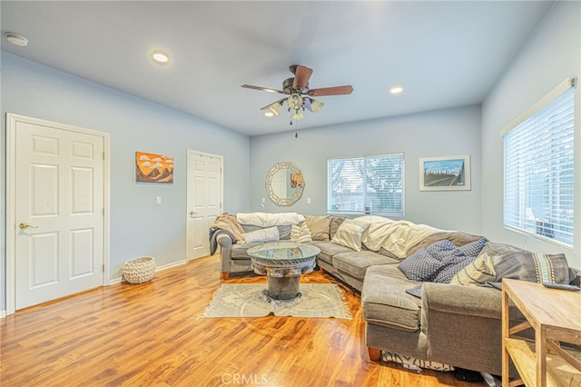 living room featuring ceiling fan and light hardwood / wood-style flooring