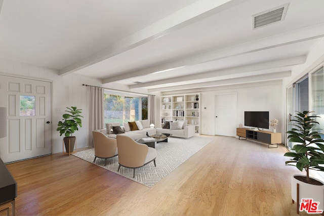 living room featuring beam ceiling, built in shelves, and wood-type flooring